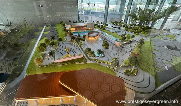 A detailed architectural scale model of Prestige Evergreen showing the clubhouse, swimming pool, landscaped gardens, and winding walkways.